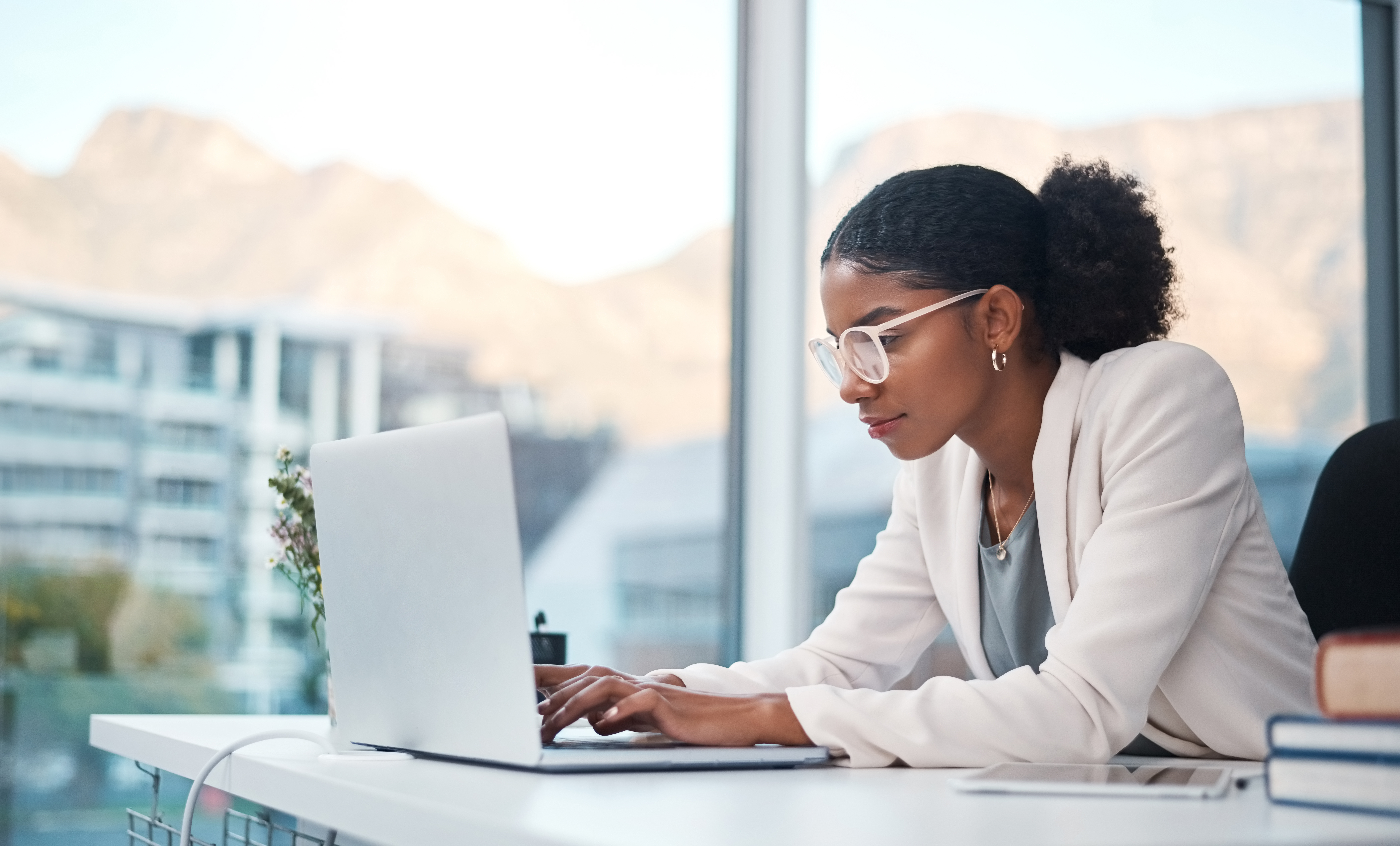 Woman at desk comparing online car insurance quotes on laptop, representing accurate quoting process for South African drivers
