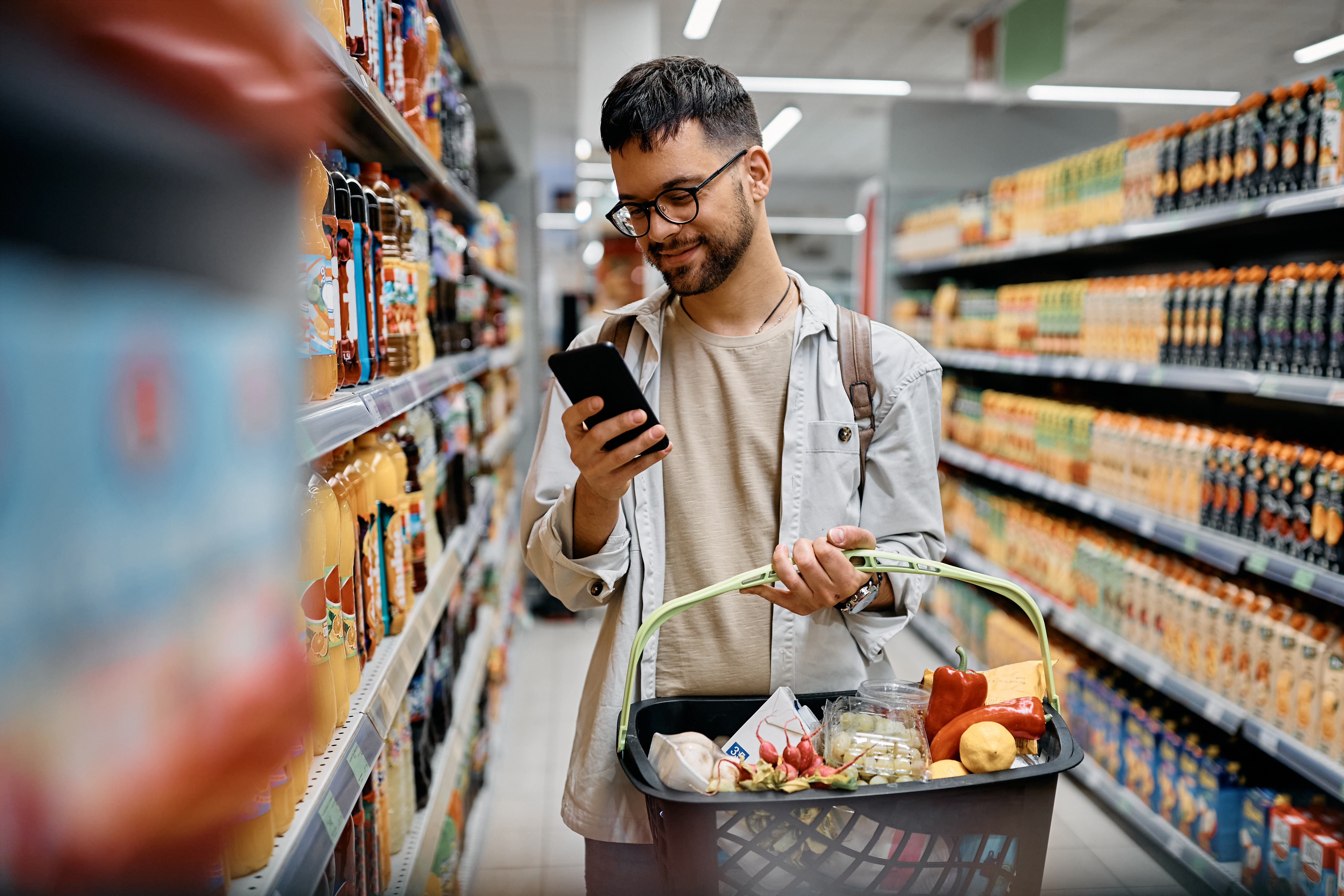 shopper using mobile phone to compare prices and manage cost of living in south african store