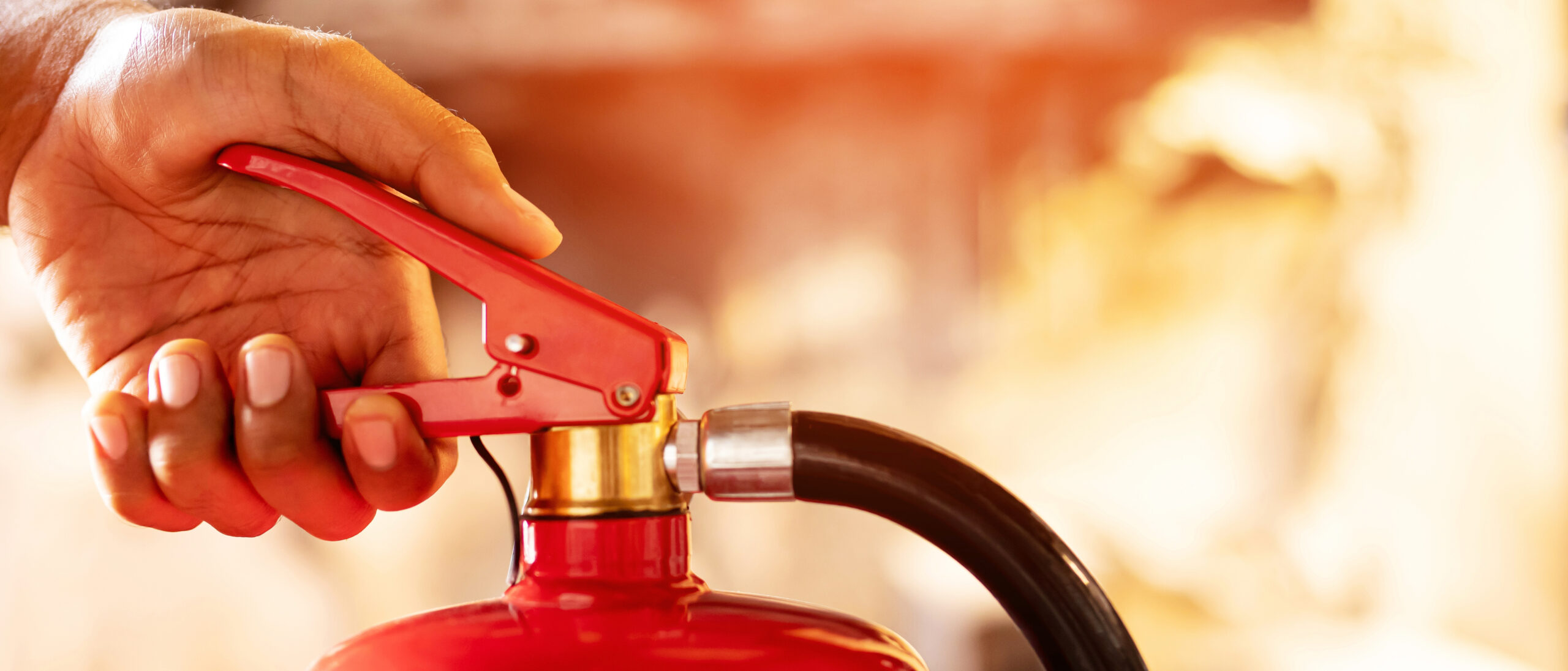 Close-up of a person using a fire extinguisher for effective fire prevention.