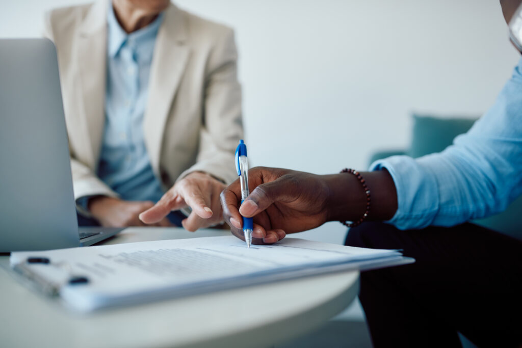 two people at a desk reviewing paperwork, discussing landlord insurance options