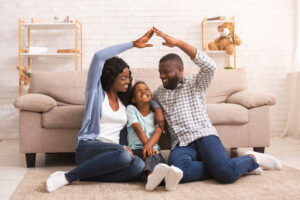 A family of three creating a heart shape with their hands, symbolizing the protection offered by Homeowners Insurance.