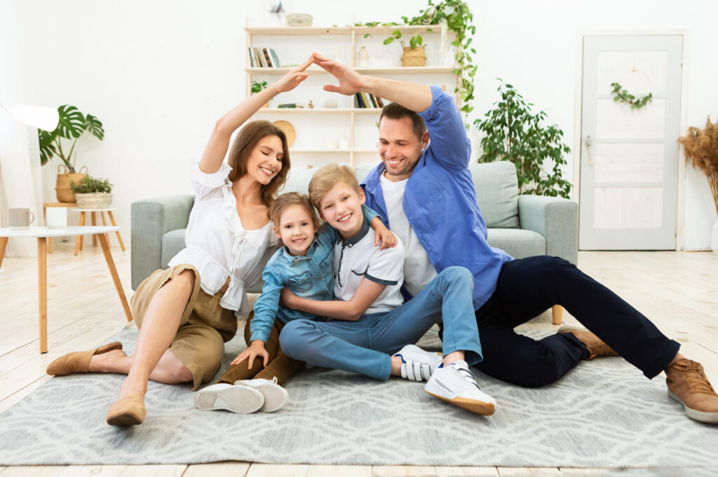 A happy family of four sitting together, symbolizing the security that Life Insurance provides